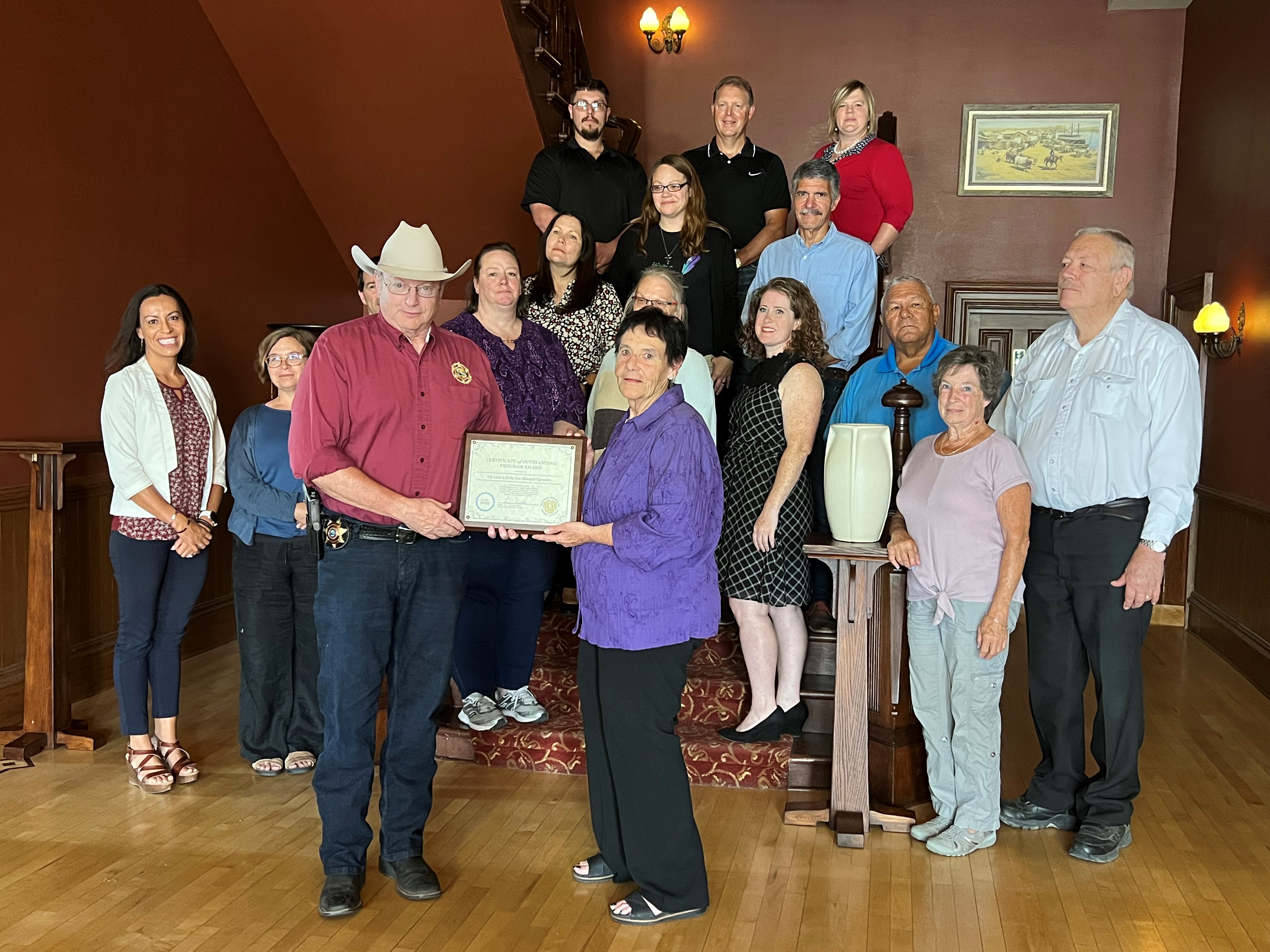Nichole Griffith and Lacey Bateman from Victim-Witness Assistance Services and the MBCC Board of Directors on the staircase at the Grant Union Hotel in Fort Benton